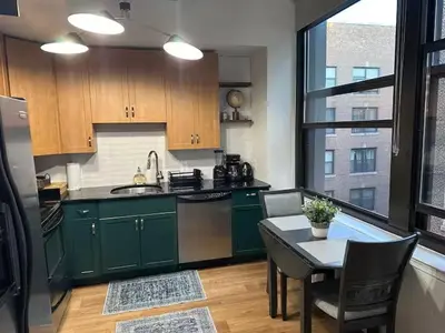 a kitchen with green cabinets and a table with a tableablish at Philadelphia Studio in Philadelphia