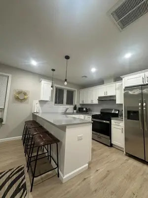 a kitchen with white cabinets and stainless steel appliances at Cozy Rooftop Home, Near Downtown Newark, EWR & NYC in Newark