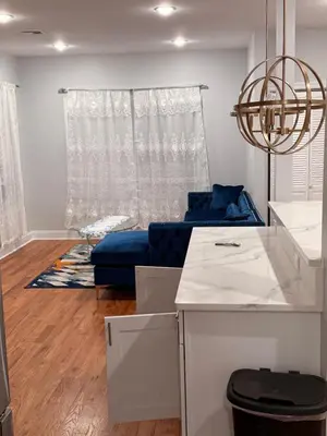 a living room with a blue couch in front of a window at Excel homes in East Orange