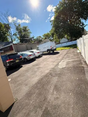 a parking lot with parked cars and a truck at Excel homes in East Orange