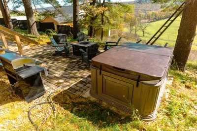 a trash can sitting in the grass next to a tree at Charming Little House at Buckleberry View EV Recharge Gorgeous View Hot Tub in Spring Mills