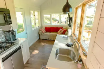 a kitchen with a sink and a living room with a couch at Charming Little House at Buckleberry View EV Recharge Gorgeous View Hot Tub in Spring Mills