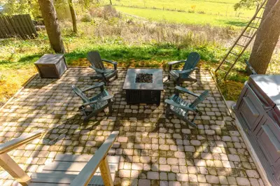 a patio with three chairs and a table and a grill at Charming Little House at Buckleberry View EV Recharge Gorgeous View Hot Tub in Spring Mills