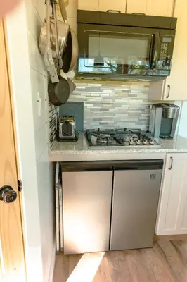 a small kitchen with a stove and a sink at Charming Little House at Buckleberry View EV Recharge Gorgeous View Hot Tub in Spring Mills