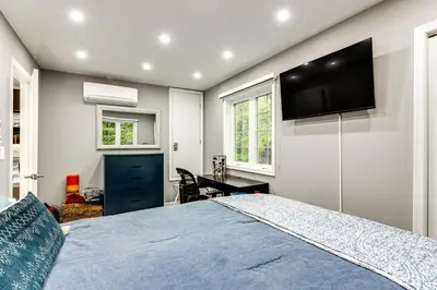 a bedroom with a large bed and a flat screen tv at Less Than 2 Mi to Big Bass Lake Modern Mtn Chalet! in Gouldsboro