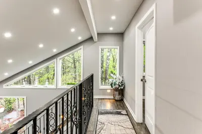 a staircase in a home with white walls and windows at Less Than 2 Mi to Big Bass Lake Modern Mtn Chalet! in Gouldsboro