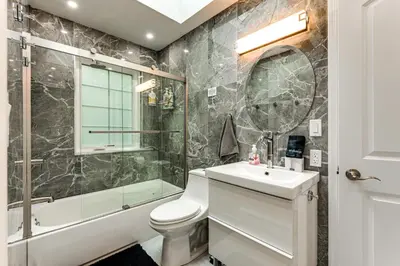 a bathroom with a toilet and a shower and a sink at Less Than 2 Mi to Big Bass Lake Modern Mtn Chalet! in Gouldsboro