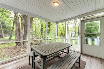 a screened porch with a picnic table and a window at Less Than 2 Mi to Big Bass Lake Modern Mtn Chalet! in Gouldsboro