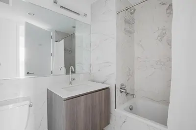 a white bathroom with a sink and a tub at Blueground Jersey City EV charging nr park NYC-1690 in New York