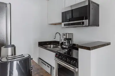 a kitchen with a sink and a microwave at Blueground Upper West Side fitness center nr Central Park NYC-1596 in New York