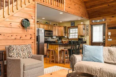 a kitchen and living room in a log cabin at Lazy River Cabin: Lakefront Stay in Greentown