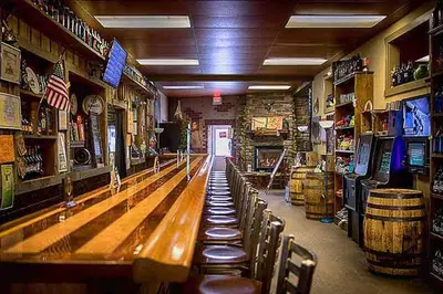 a bar with a row of wooden tables and chairs at Honesdale Escape ~ A Place to Remember - Apartment in Honesdale
