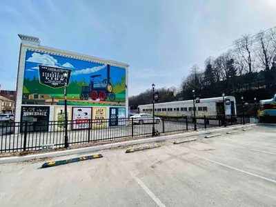a billboard in a parking lot next to a train at Honesdale Escape ~ A Place to Remember - Apartment in Honesdale