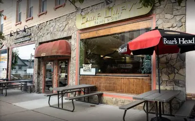 a cafe with benches and an umbrella in front of a store at Honesdale Escape ~ A Place to Remember - Apartment in Honesdale