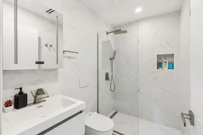a white bathroom with a shower and a sink at 24 Stay - Philadelphia Rittenhouse in Philadelphia