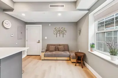 a living room with a couch and a window at 24 Stay - Philadelphia Rittenhouse in Philadelphia