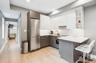a kitchen with a stainless steel refrigerator and white cabinets at 24 Stay - Philadelphia Rittenhouse in Philadelphia