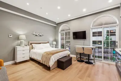 a bedroom with a bed and a desk and windows at 24 Stay - Philadelphia Rittenhouse in Philadelphia