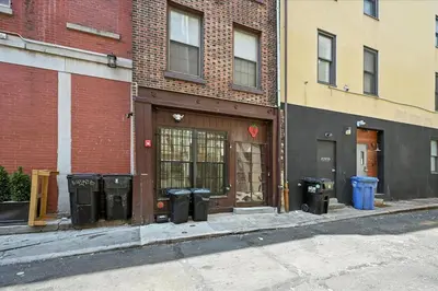 a building with trash cans on the side of a street at Cozy Modern Studio Perfect for Short or Long Stays in Philadelphia