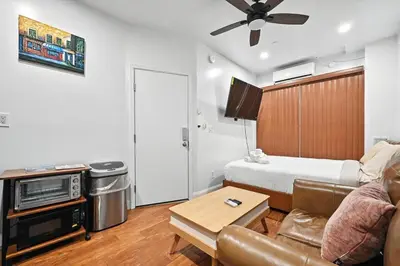 a living room with a couch and a bed at Cozy Modern Studio Perfect for Short or Long Stays in Philadelphia