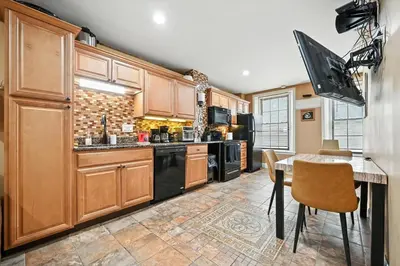 a kitchen with wooden cabinets and a table with chairs at Heart of Downtown Delight in Philadelphia