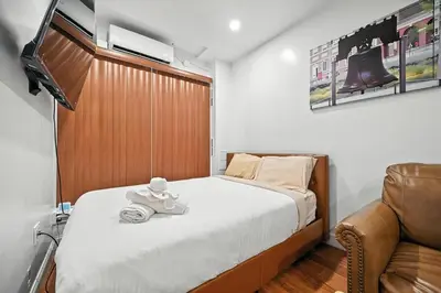 a small bedroom with a bed and a chair at Heart of Downtown Delight in Philadelphia