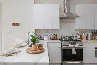 a kitchen with white cabinets and a stove at Travelers Dream that's Mins to NYC having Game Room and Parking in Jersey City