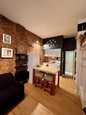 a kitchen and living room with a table and chairs at Gotham House in New York