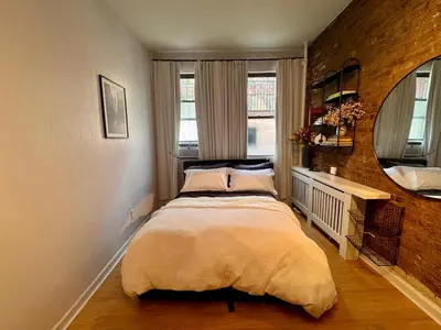 a bedroom with a bed and a mirror at Gotham House in New York