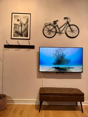 a flat screen tv hanging on a wall with a bike on it at Gotham House in New York