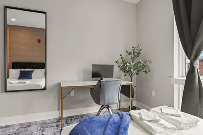 a bedroom with a desk with a computer and a mirror at Aparmint at Five on Canal - Philadelphia in Philadelphia