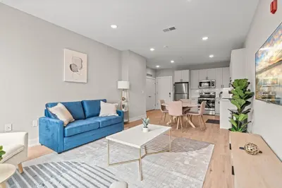 a living room with a blue couch and a table at Aparmint at Five on Canal - Philadelphia in Philadelphia