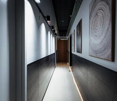 a hallway with a door and some paintings on the walls at CityNest Hotel in New York