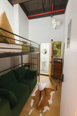 a living room with a green couch and a bunk bed at CityNest Hotel in New York
