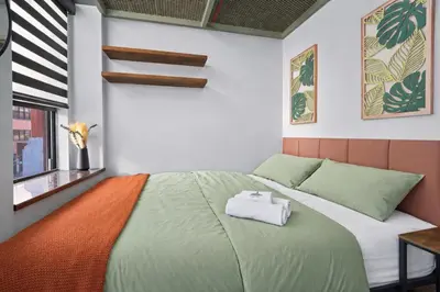 a bedroom with a bed with an orange and green blanket at CityNest Hotel in New York