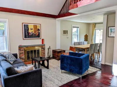 a living room with a fireplace and a table at Catskills Lakefront with Kayaks, HotTub & Firepit in Swan Lake