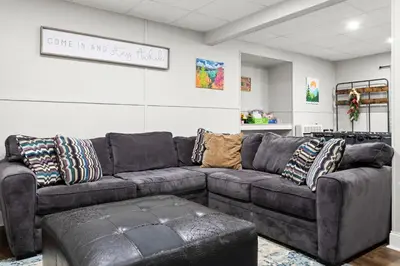 a living room with a brown leather couch at Vaulted Pines Lodge Hot Tub Game Room in Albrightsville