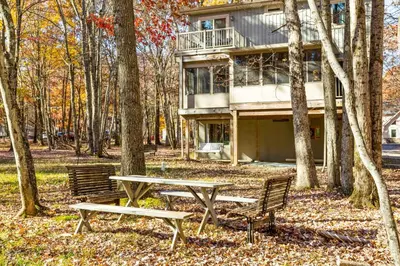 a table and benches in front of a house at Vaulted Pines Lodge Hot Tub Game Room in Albrightsville