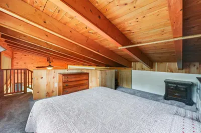 a bedroom with a bed with a fireplace and wooden ceilings at Near State Parks Countryside Cottage in Wellsboro in Wellsboro