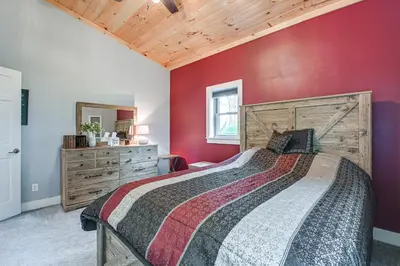 a bedroom with a bed with a red wall at Near State Parks Countryside Cottage in Wellsboro in Wellsboro