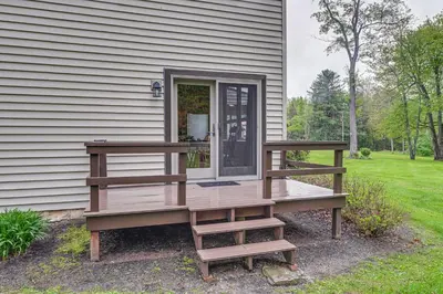 a house with a wooden deck next to a house at Near State Parks Countryside Cottage in Wellsboro in Wellsboro