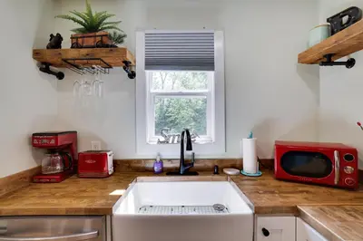 a kitchen with a sink and a red microwave at Apartment Minutes from Camelback Mountain with Washer Dryer in Tannersville