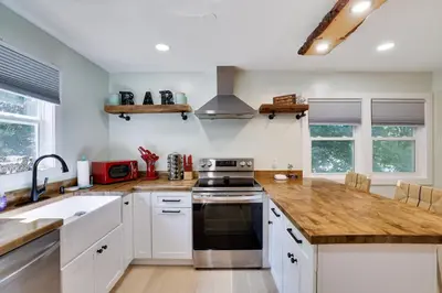 a kitchen with white cabinets and wooden counter tops at Apartment Minutes from Camelback Mountain with Washer Dryer in Tannersville