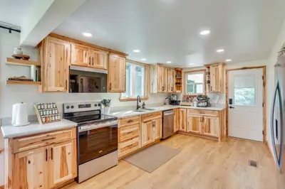 a kitchen with wooden cabinets and a refrigerator at Steps to Susquehanna River Hot Tub Hideaway! in Dauphin