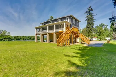 a large house on a grassy field with a tree at Steps to Susquehanna River Hot Tub Hideaway! in Dauphin