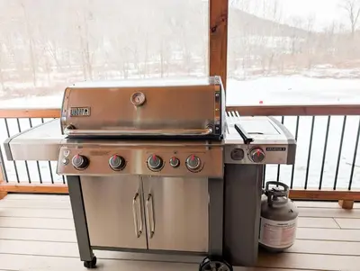 a grill sitting on top of a stove on a porch at Fully Loaded Riverfront West Branch Fishing Cabin in Deposit