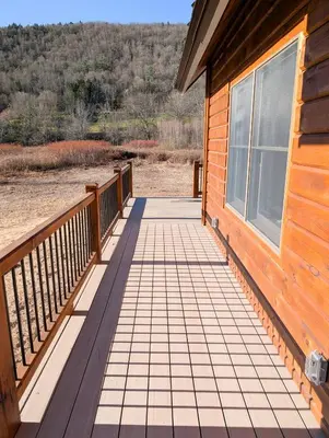 a wooden porch on a house with a window at Fully Loaded Riverfront West Branch Fishing Cabin in Deposit
