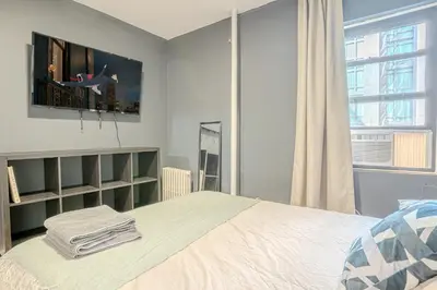 a bedroom with a large bed and a window at Stylish 3BD Near Empire in New York