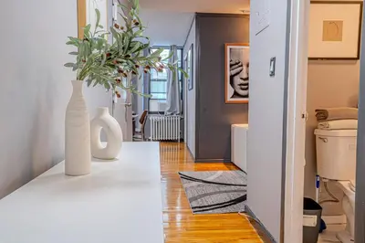 a living room with a white vase on a table at Stylish 3BD Near Empire in New York