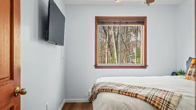 a bedroom with a bed and a window at Access to Private Lake Pools Sports Complex • Fire Pit Foxden by AvantStay in East Stroudsburg